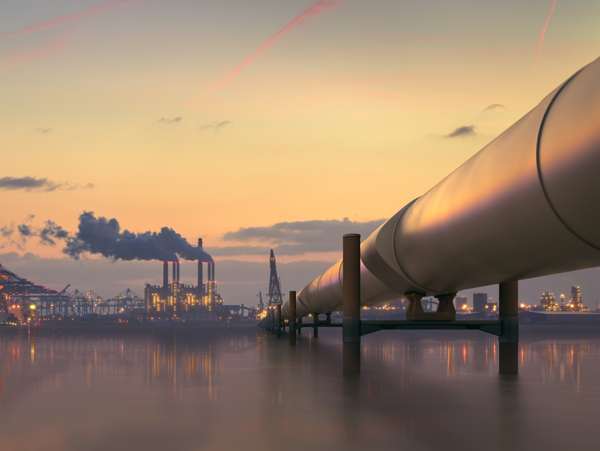 Oil pipeline in industrial district with factories at dusk